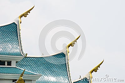 Small finials jutting out of the side â€“ corners of the blue gable roof, representing the heads of naga. Stock Photo